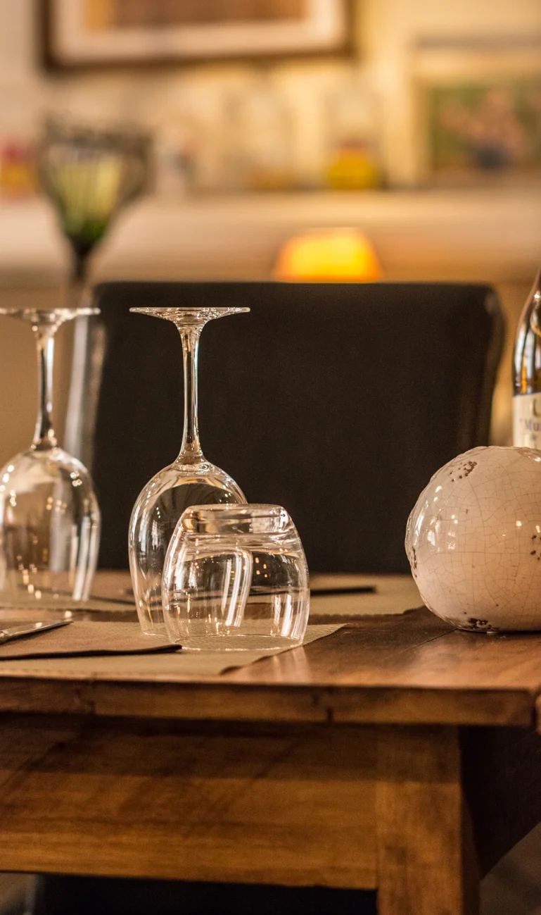Table dressée à L'Auberge Provençale, verres et lumière tamisée — l'ambiance d'un dîner cadeau